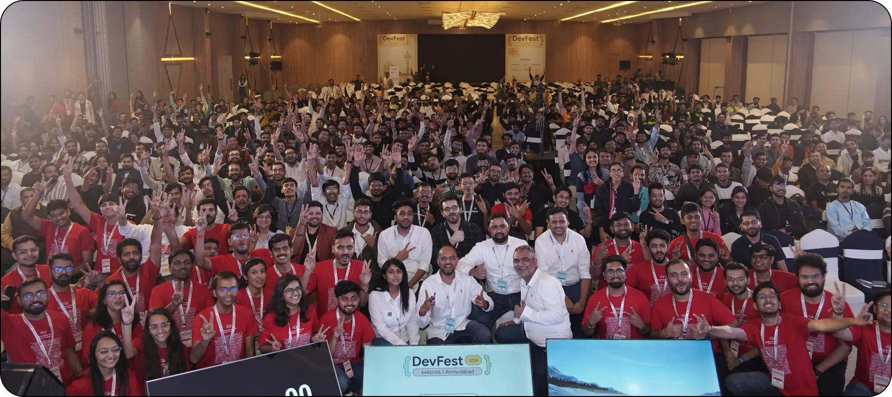 A vibrant group photo of attendees, speakers, and organizers at GDG DevFest Ahmedabad